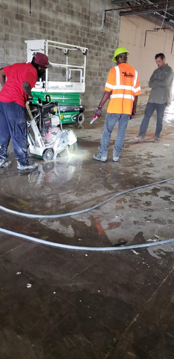 Crew performing commercial concrete floor cutting